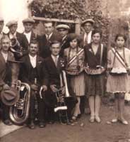 Après le défilé, quelques musiciens, dont Belo et son basson, entourés des "prieuresses" et de quelques amis (vers 1925). Document : archives du musée de Pigna.